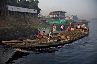 A boat carrying soil, used for filling up low land, through the Shitalakhya River, near the Tongi bridge, on the outskirts of Dhaka city. Bangladesh. February 19, 2007. by Unbekannt Unbekannt